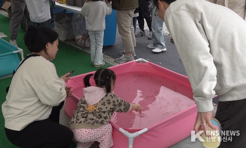 (사진촬영=한국방송뉴스 통신사) 어린아이가 물고기 체험을 하고 있다.