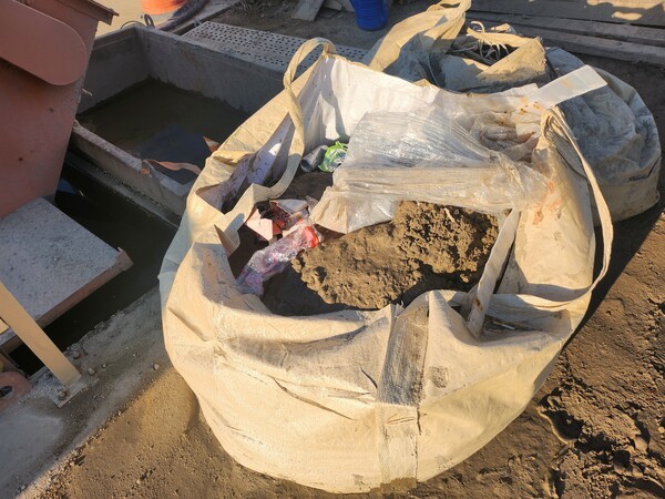 세륜기에서 나온 슬러지가 세륜기 설치시설 주변 바닥에 흘러내려 (톤백, 마대) 방치된 현장