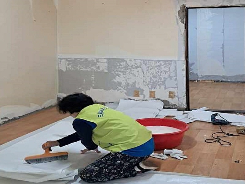 (광명1-1)드림하우스 봉사단원이 주거 상향 지원사업 대상자의 가구에서 도배 봉사를 하고 있다..jpg