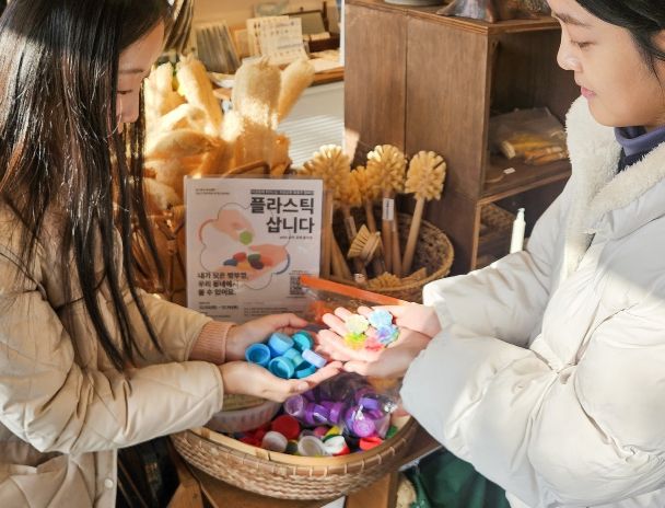 어궁동 일원에서 플라스틱 병뚜껑을 꽃동전과 교환하는 모습