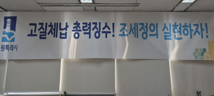 ‘고질체납 총력 징수! 조세정의 실현하자!’ 수원시 징수과 사무실에 걸려 있는 현수막.