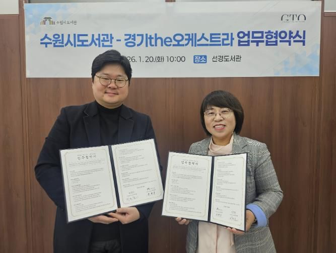 최현주 수원시도서관사업소장(오른쪽)과 허석환 경기더(the)오케스트라 관계자가 협약 후 기념촬영을 하고 있다.