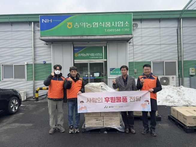 송악면 행복키움추진단과 송악농협 관계자들이 떡국떡 후원 전달식을 갖고 기념촬영을 하고 있다.