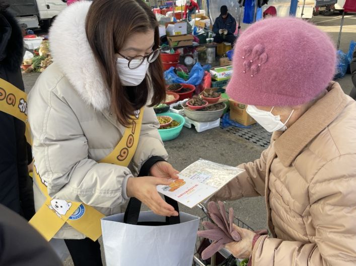 정신건강 전담 인력이 청양시장에서 리플릿 및 홍보물품을 배부하고 있다.