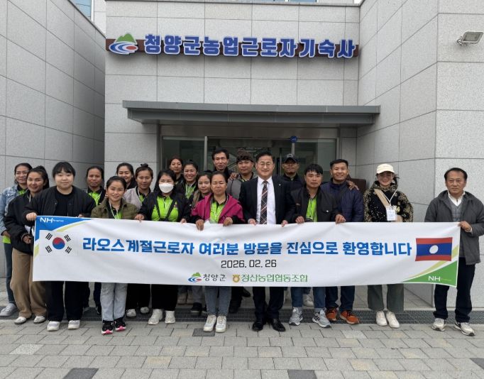 지난 26일 입국한 라오스 계절근로자들이 청남면 농업근로자 기숙사 앞에서 기념촬영을 하고 있다.