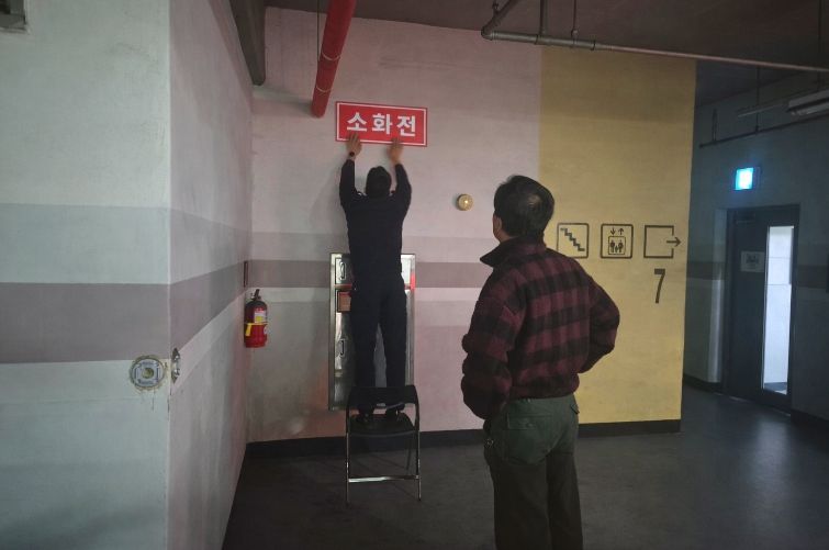영동소방서 관계자가 아파트 지하주차장에 '보이는 소화전' 표지를 부착하고 있는 모습