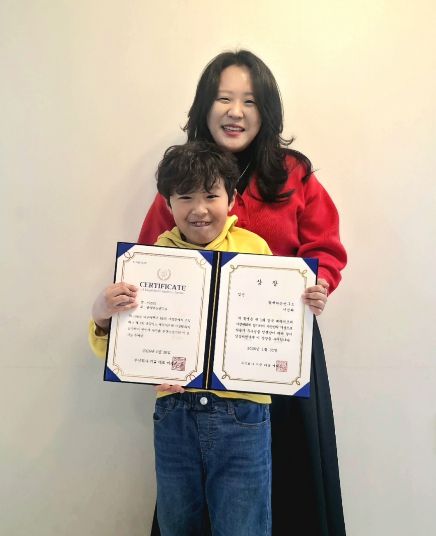 함께하는연구소 박현지 소장(뒤)과 연구소 이용 아동 이건희 군이 「제1회 경북 베리어프리 사생대회」 수상을 기념해 촬영한 모습