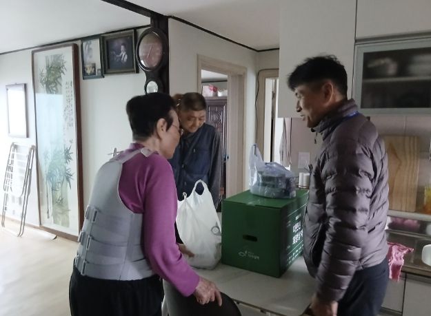 영인면 행복키움추진단원이 어르신 가정을 방문해 후원받은 황태국과 반찬 꾸러미를 전달하고 있다.